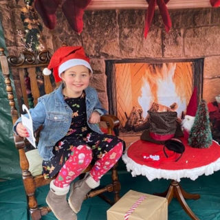 A child sitting next to a fireplace